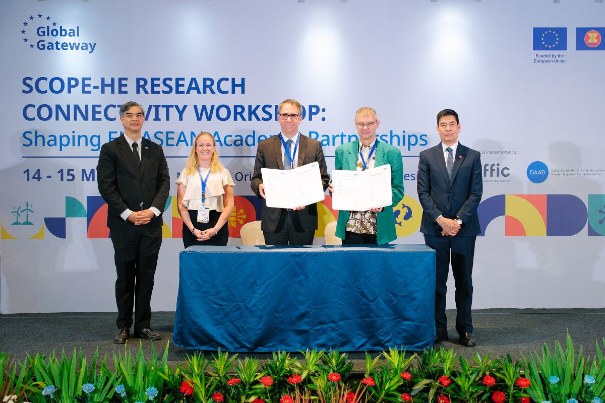 Five people on a stage, two with documents (GreenTrans-Edu kick-off meeting in Jakarta)