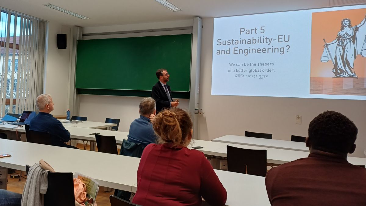 several people sitting at tables watching a person talking